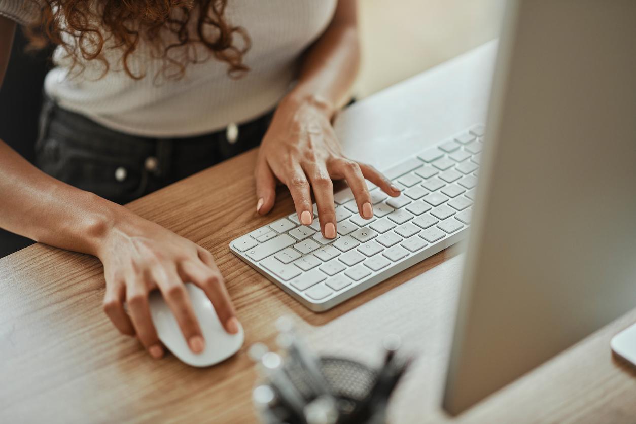Mans de muller usando un rato e un teclado.