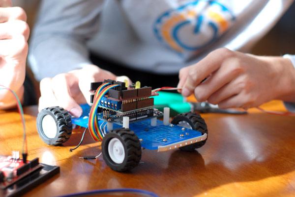 Manos trabajando en un proyecto de robótica.